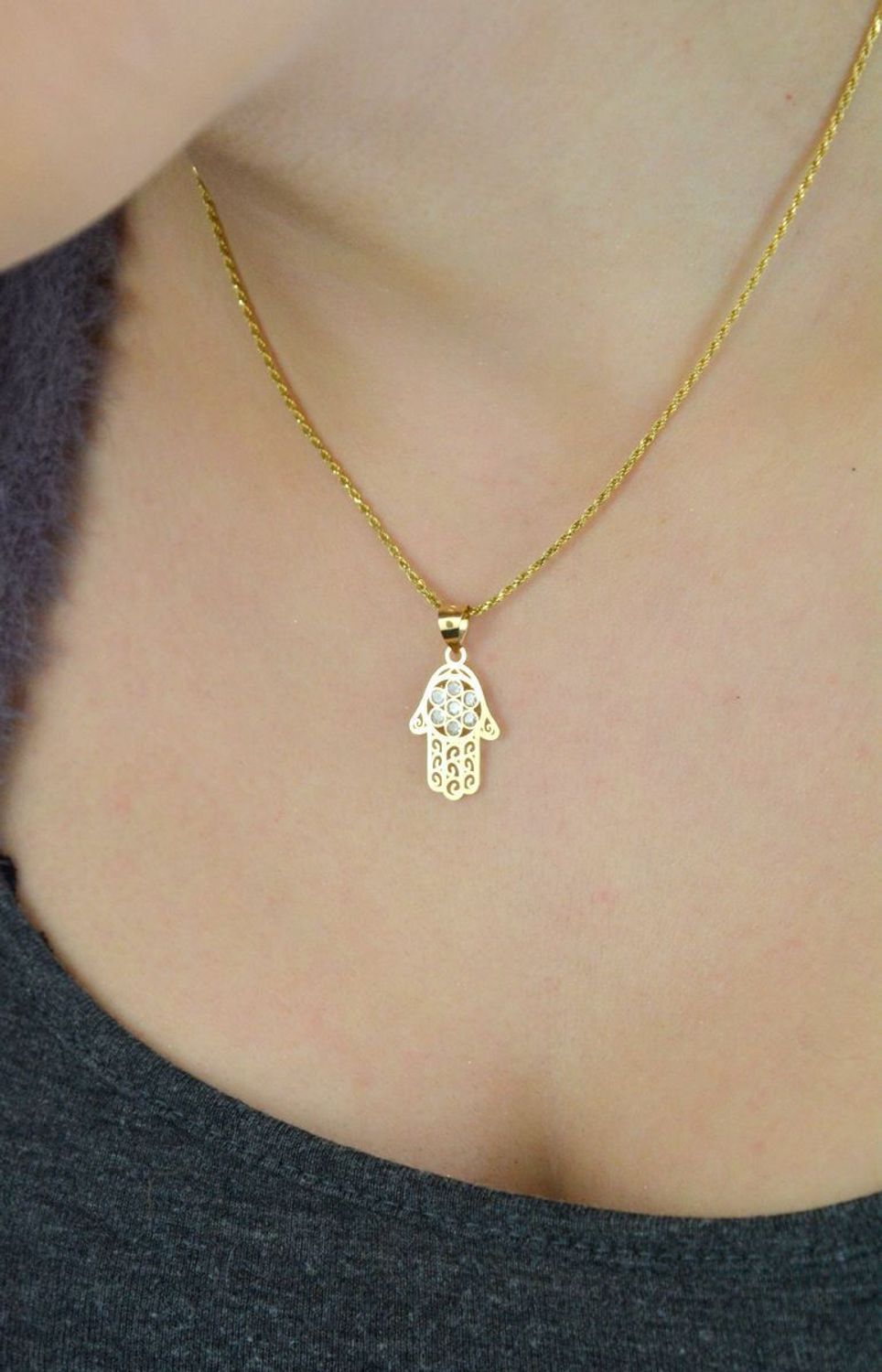 Zawieszka złota Ręka Fatimy próby 585, zdobiona cyrkoniami. Wymiary 2,5×1,3 cm, waga 0,61 g. Idealna jako prezent lub talizman ochronny.1.jpg